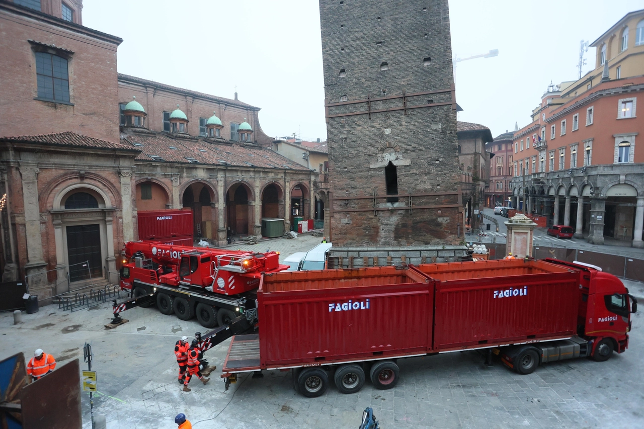 Gli operai della Fagioli in azione sotto la Garisenda (Foto Schicchi)