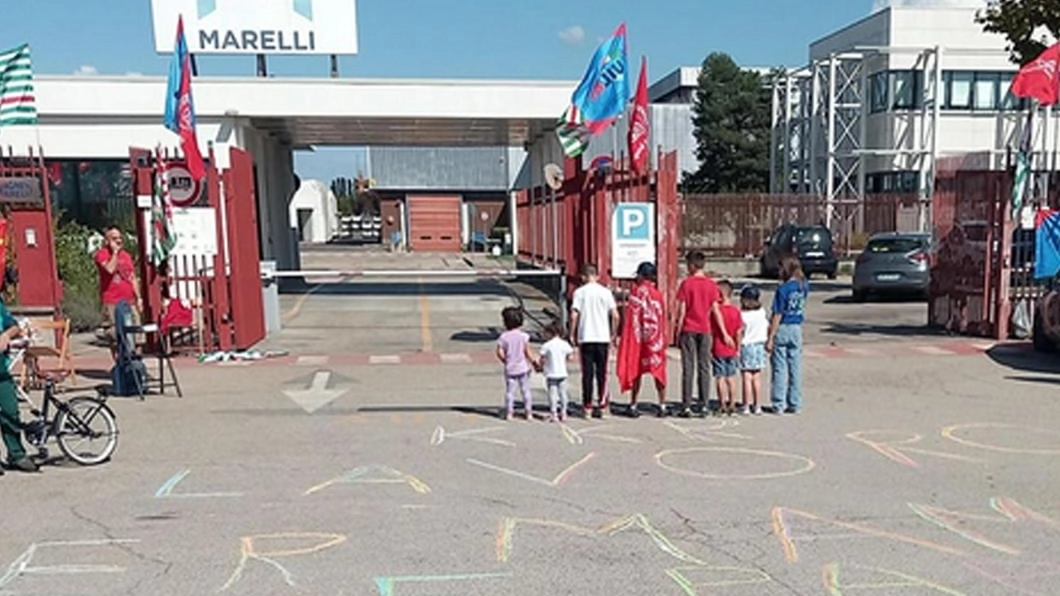 Marelli, il giorno dei figli: "Lavoro per mamma e papà". Scritta davanti allo stabilimento