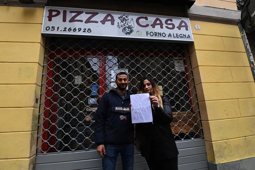 Flavia Dauti e Ayman Marzouic, di fronte alla saracinesca abbassata di Pizza Casa