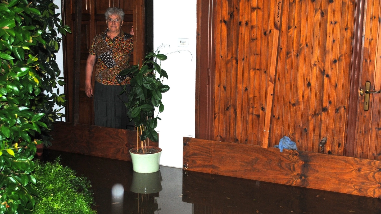 Badia, una donna innalza alcune barriere per proteggere la casa dall’onda d’acqua e fango