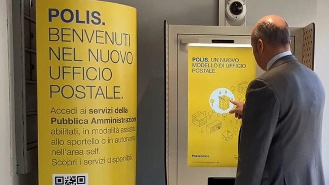 Un cliente di Poste italiane allo sportello bancomat del nuovo ufficio postale ora predisposto per i servizi Polis