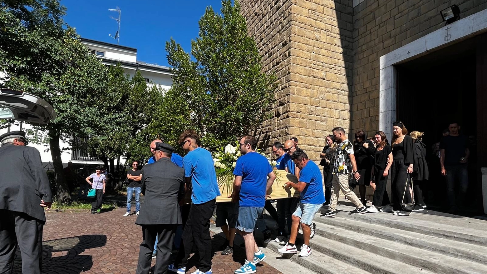 I collegi portano il feretro fuori dalla chiesa Regina Pacis