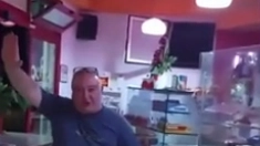 Giovanni Mundo in un fermo immagine del video ritratto in un bar mentre canta Faccetta Nera, facendo il saluto romano