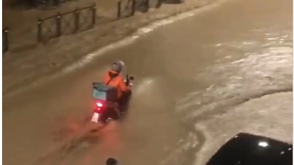 Un rider durante una consegna all’altezza delle allagate vie Andrea Costa e Guerrini