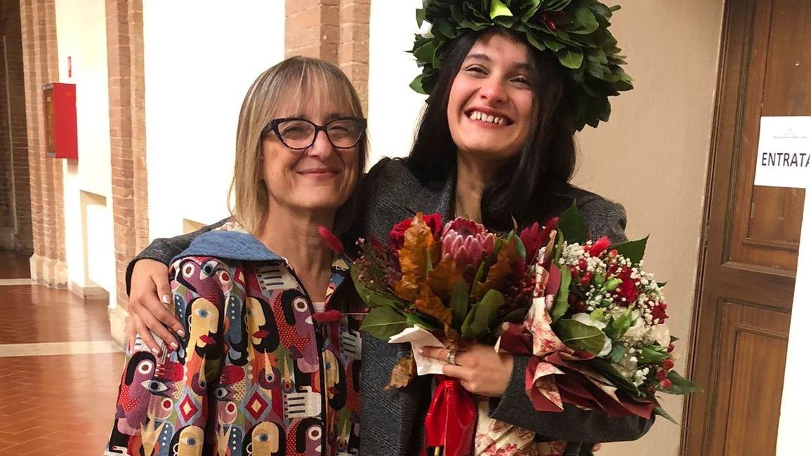 La laurea di Erika Merlonghi a Siena, nonostante le sfide uditive, è un successo reso possibile grazie all'assistenza di Donatella Del Medico.