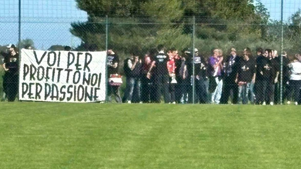 I tifosi a bordo campo, ma dietro la rete, che esibiscono lo striscione con la scritta ’Voi per profitto, noi per passione’