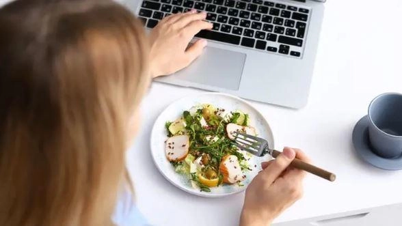 Un’impiegata consuma il pranzo davanti al pc, in ufficio (foto d’archivio)