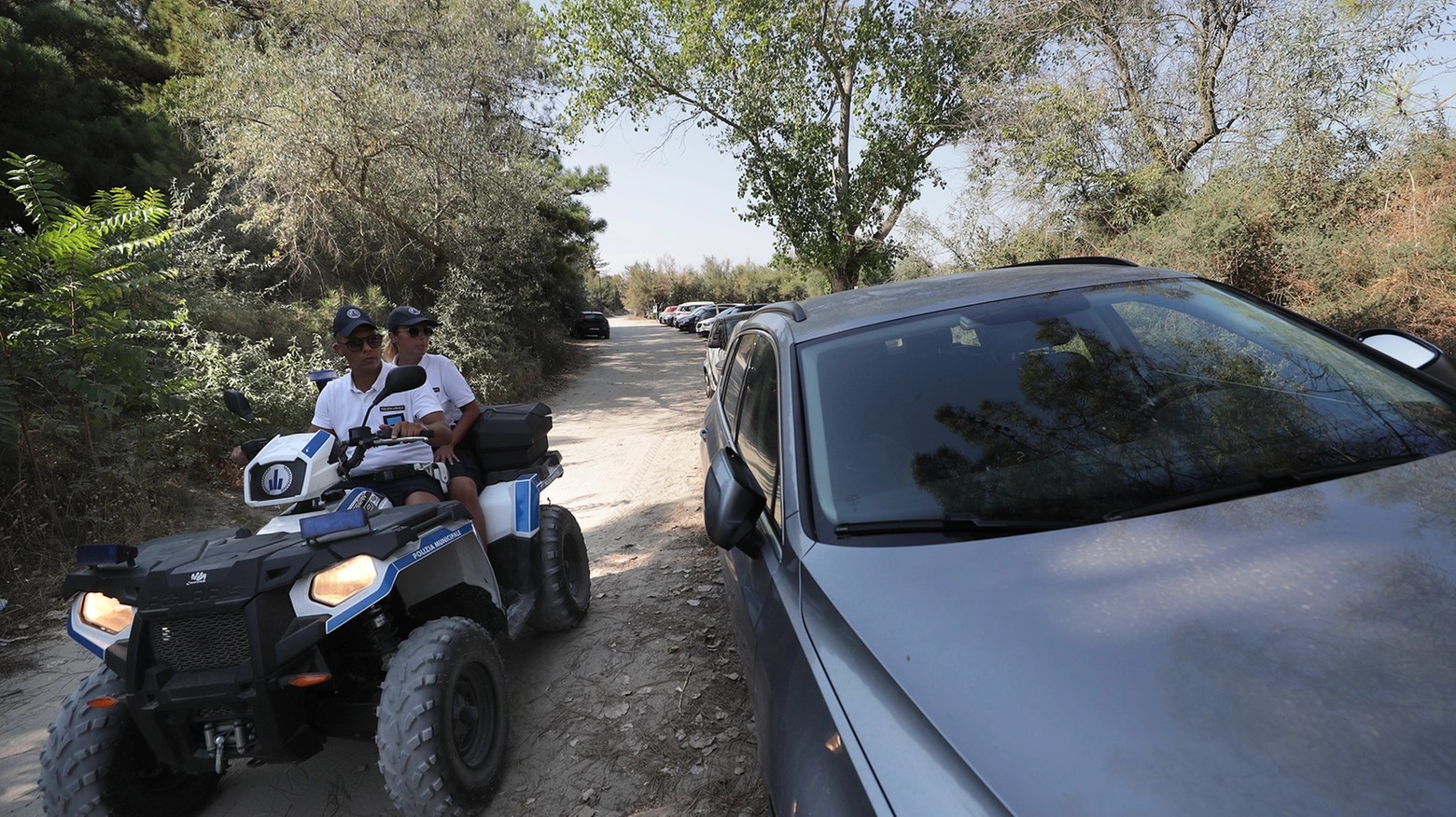 Agenti della polizia locale  di Ravenna intenti  a controllare  le auto parcheggiate sui lidi in una foto d’archivio