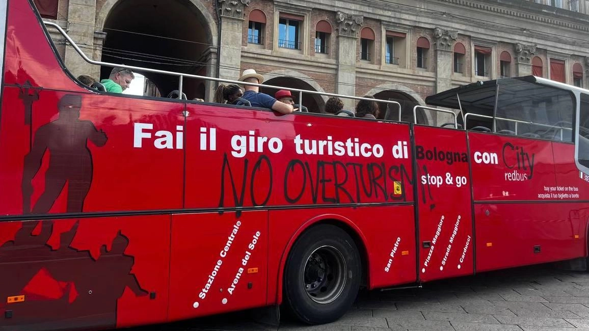 La fiancata del City red bus che fa il giro della città con i turisti a bordo, con la scritta ’No overtourism’: la protesta è del collettivo Luna