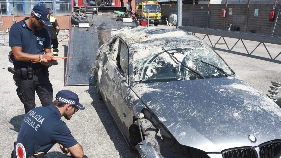 La Bmw alla cui guida si trovava il 22enne Alberto Battistini. Sotto, il recupero del veicolo da via Monte Cieco