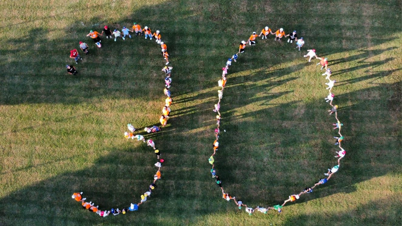 La coreografia organizzata da animatori e bambini per festeggiare i 30 anni di Estate Ragazzi a Loiano catturata dalla ripresa aerea di un drone