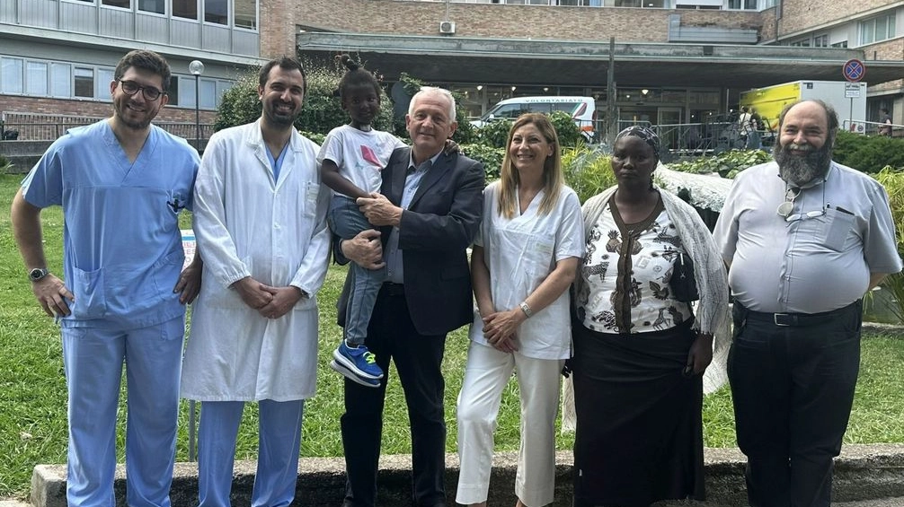 La bambina in braccio a Marco Mastacchi, presidente Opera Padre Marella assieme alla nonna, al diacono Eros  e ai medici