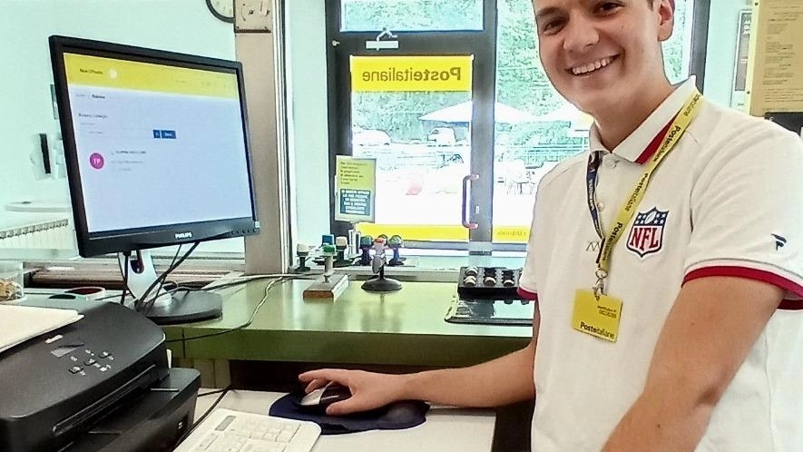 Marcello Ciaroni, 22 anni, è il più giovane dipendente dell'ufficio postale di Trasanni, Urbino. Simbolo del ricambio generazionale in atto in Poste Italiane, dimostra impegno e soddisfazione nel suo lavoro, evidenziando l'importanza di valorizzare i giovani.