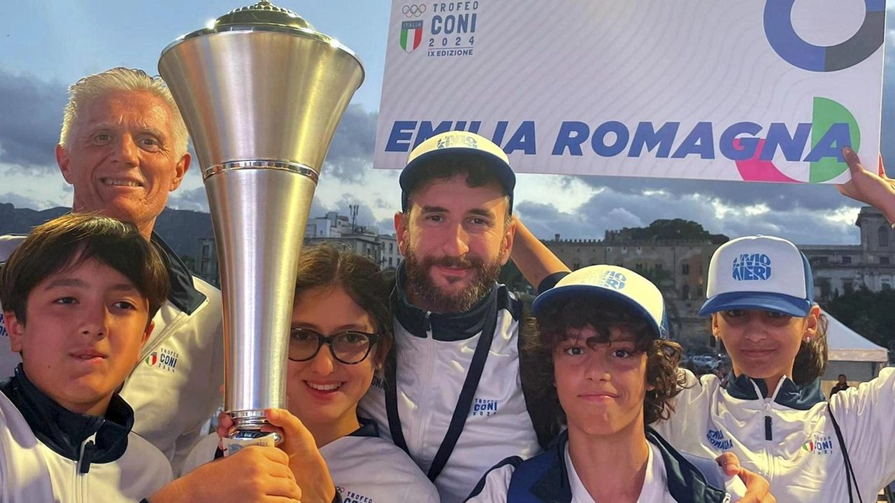 Il gruppo degli atleti della ’Livio Neri’ accompagnato da Fulvio Neri mentre. alza al cielo della Sicilia il trofeo assegnato ai vincitori del Torneo Coni