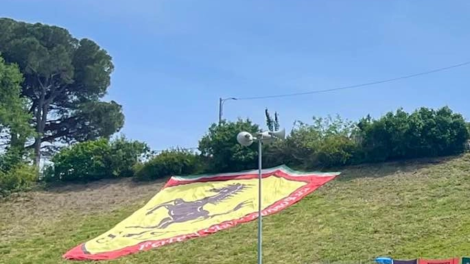 L’enorme Scudo Ferrari del club di Caprino Bergamasco esposto alla Tosa in una zona interdetta al pubblico. A lato, una veduta aerea (foto Isolapress)