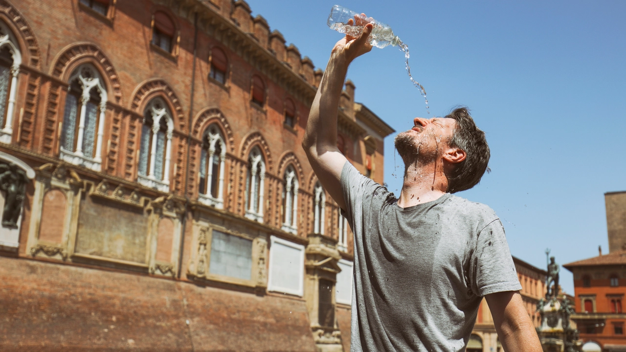 Un uomo in piazza a Bologna mentre tenta di rinfrescarsi