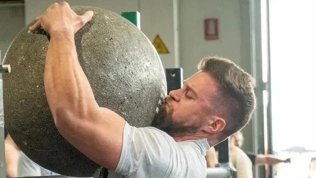 Matteo Cardinali, campione italiano di Strongman, muove una palla di cemento