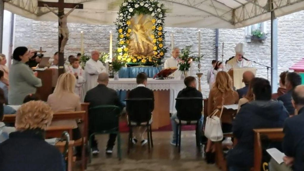 La cresima nel tendone, sullo sfondo l’immagine di San Michele Arcangelo