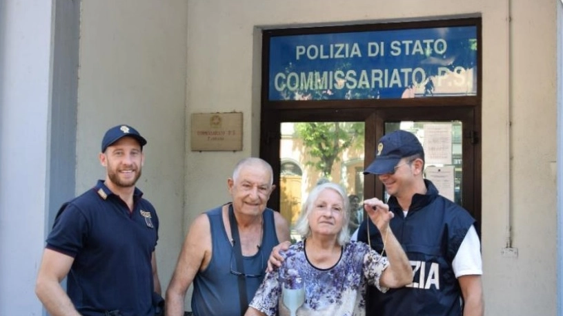 L'anziana, emozionata, riceve la collana dalle mani dei poliziotti