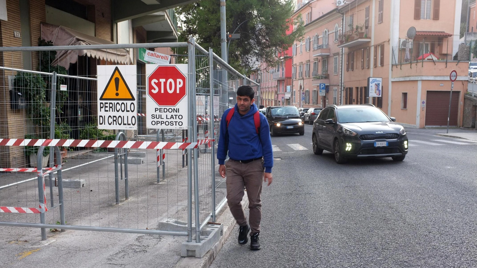 Tratto di marciapiede off-limits. Pedoni lungo la strada tra le auto