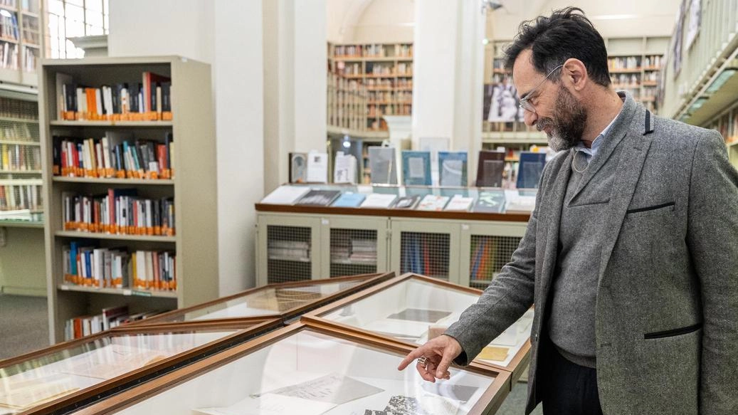 Il curatore Paolo Tinti con i libri in mostra. alla. biblioteca Poletti