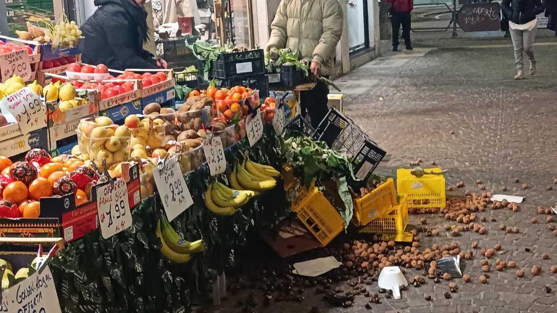 Lancia bottiglia contro negoziante. Poi gli rovescia il banco della frutta