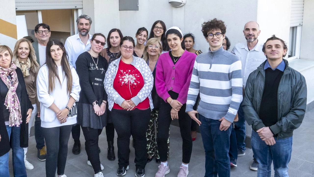 Ragazzi e operatori davanti al condominio di via Fornarina con l’assessore Davide Agresti (foto Tedioli)